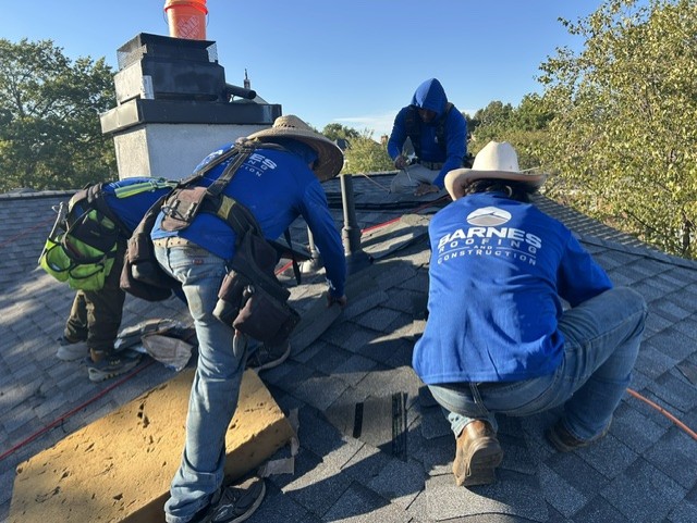 The Barnes crew installing new shingles around the chimney